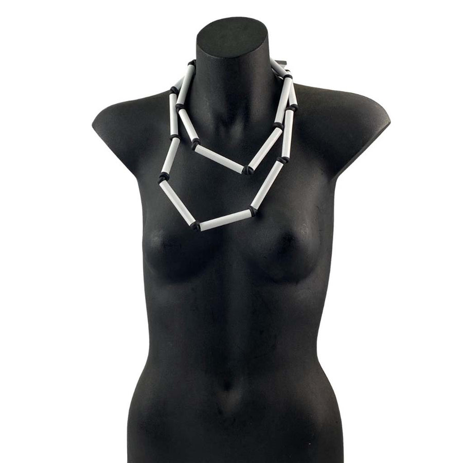 short black and white rod necklace on a torso mannequin