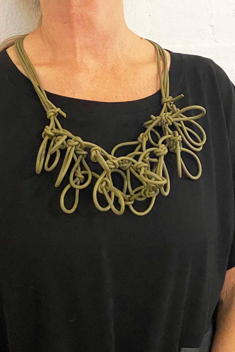woman wearing a green statement necklace