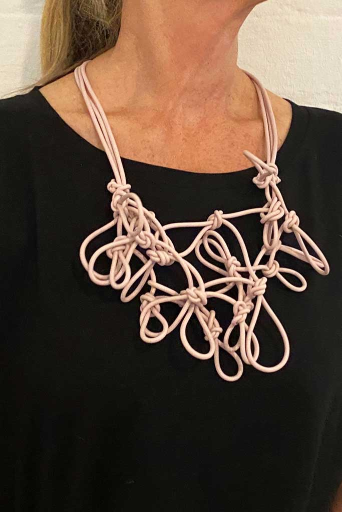 woman wearing a pink statement necklace