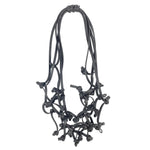 black knotted rubber necklace on a white background