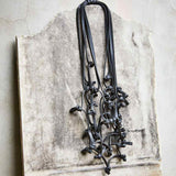 black knotted rubber necklace long black rubber necklace on a stone backdrop