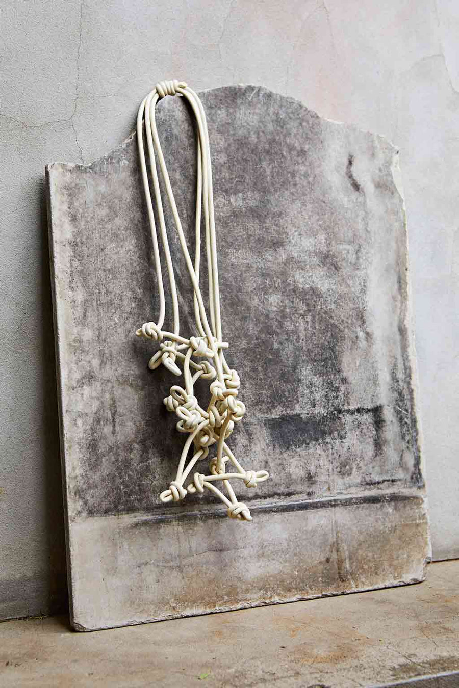 cream knotted necklace on stone backdrop