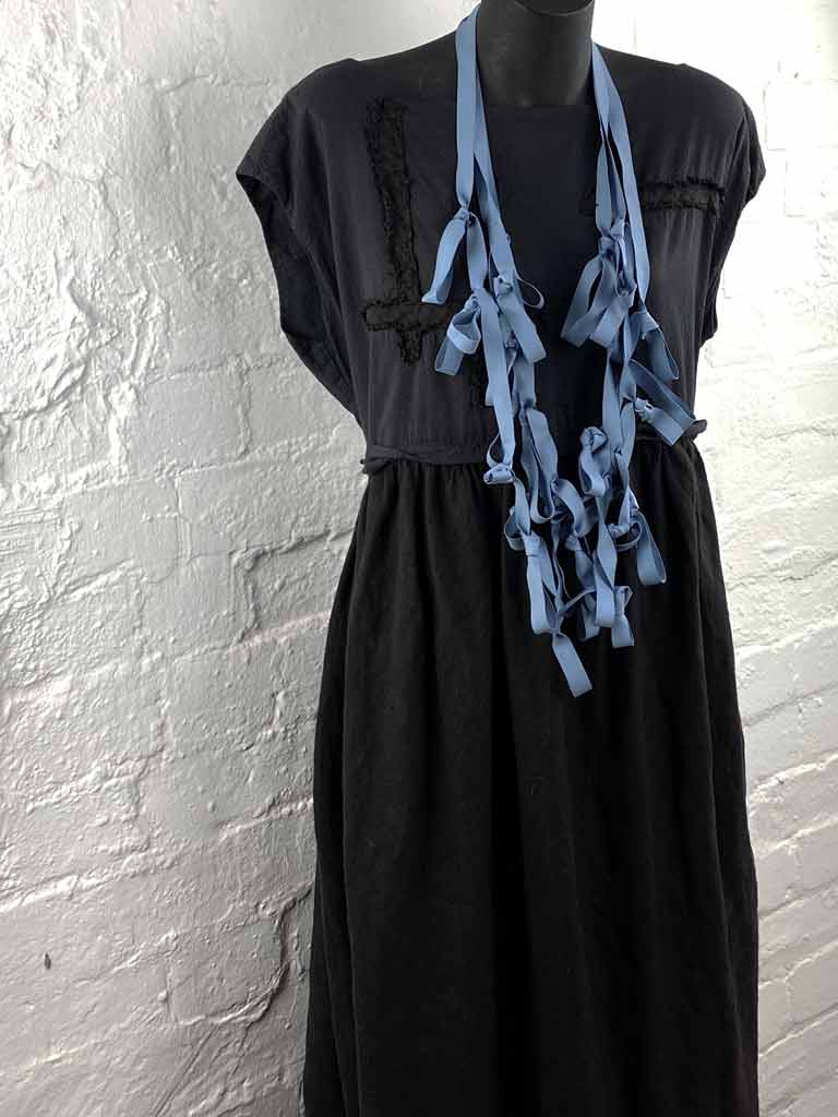 steel-blue long boho rubber necklace on a mannequin